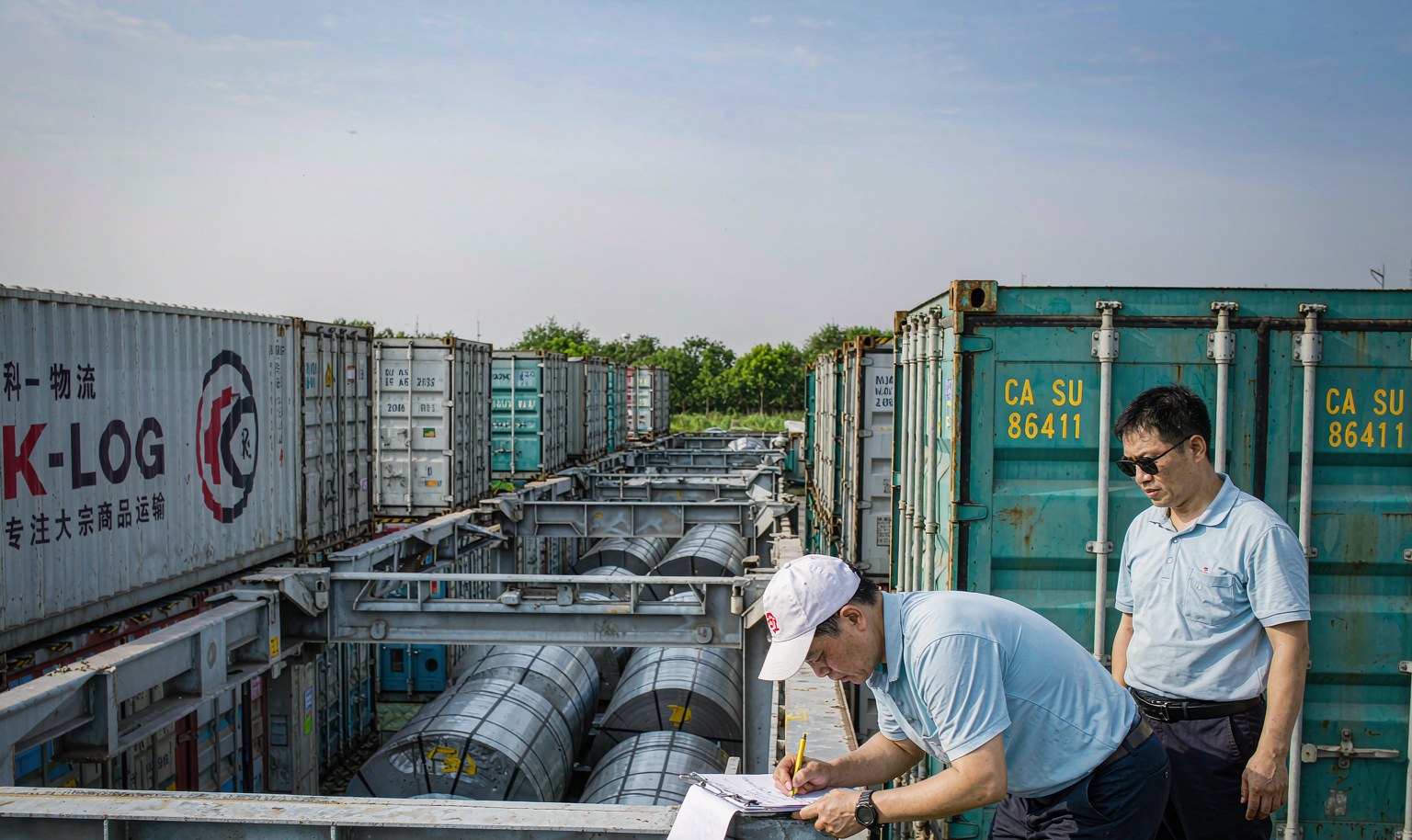 Workers checking containers at a customs clearance area