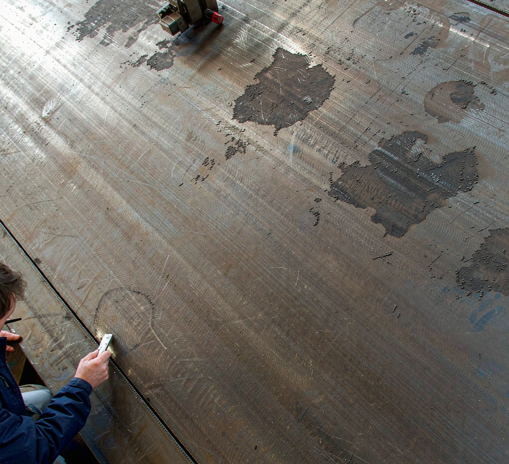 A36 carbon steel plate surface being inspected for mill scale