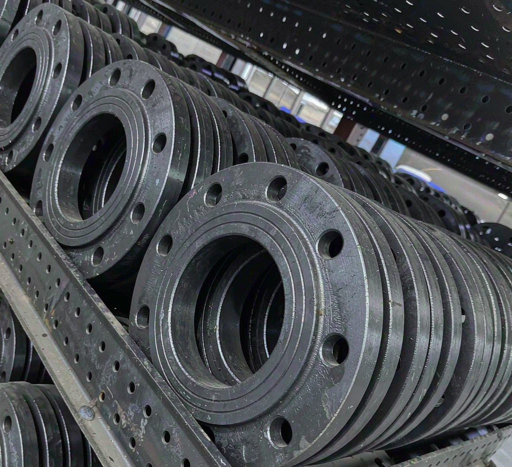 ASTM A105 carbon steel forged flanges stacked in a warehouse