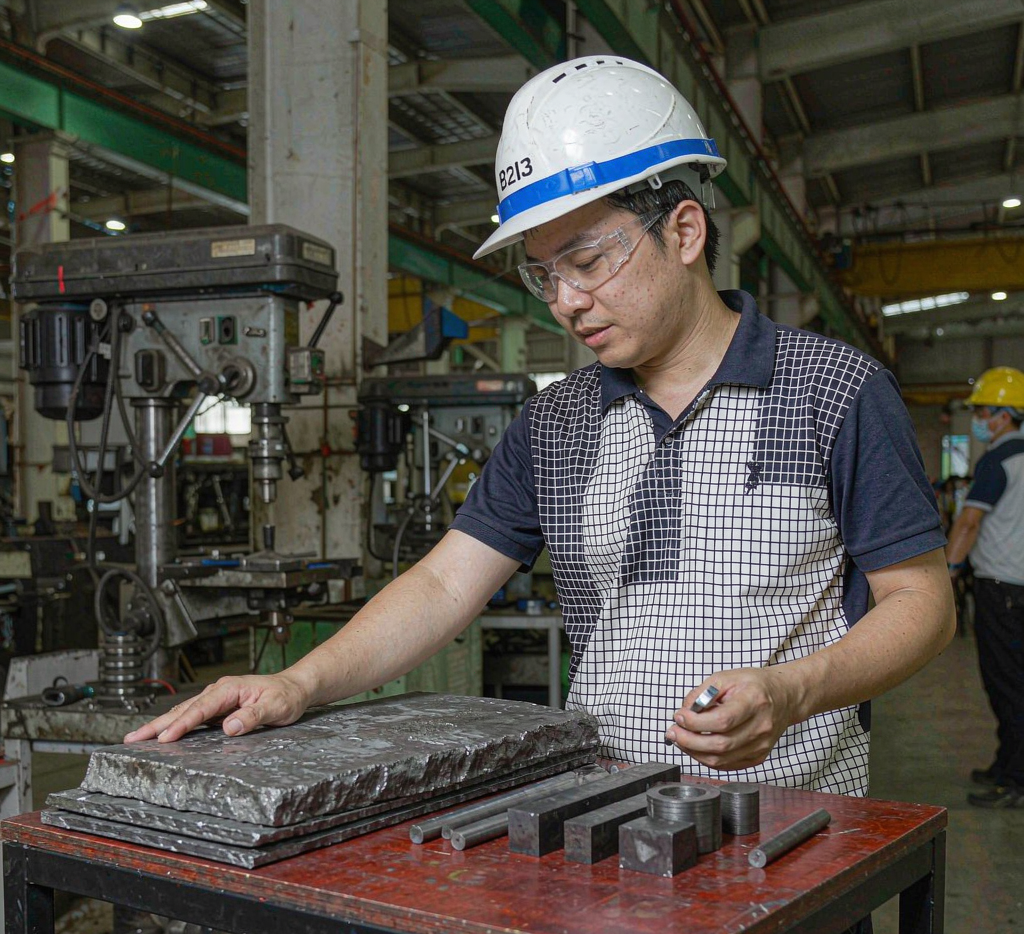 Engineer comparing hot rolled and cold drawn steel samples