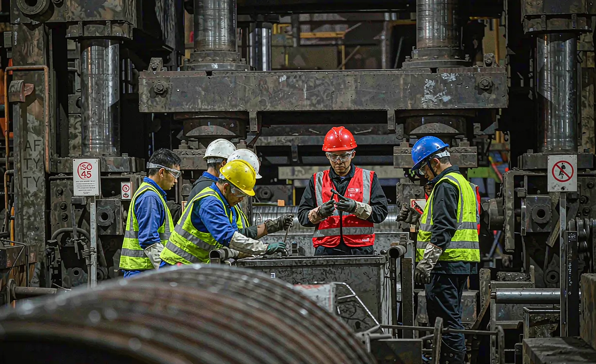Factory auditor reviewing ISO certificates during carbon steel mill visit