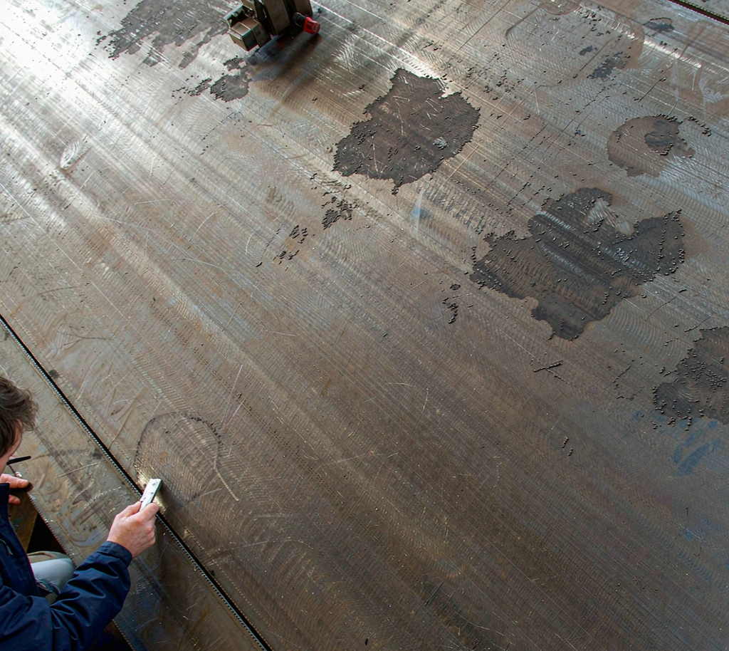 A36 carbon steel plate and structural sections stacked in a mill warehouse
